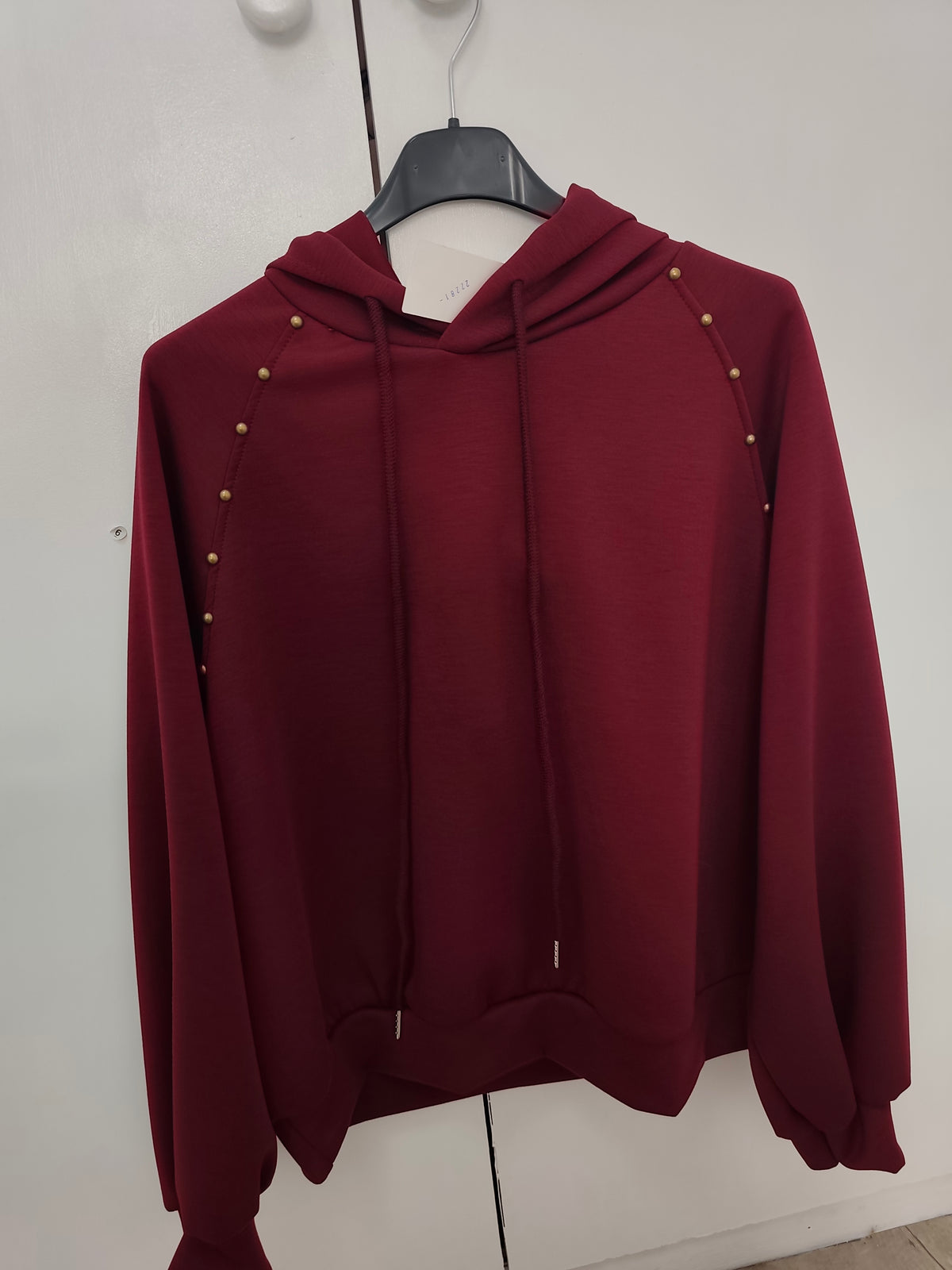 Sudadera con capucha y tachuelas doradas